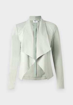 Chaqueta de color verde claro, de manga larga y con el frente abierto, con un cuello drapeado y una textura suave y lisa. Fabricada con una tela elástica.