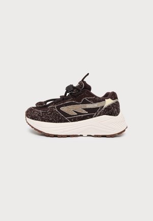Mørkebrun tekstureret sneaker med beige logo, hvid tyk sål og sorte elastiske snørebånd med en lås, vist fra siden på en hvid baggrund.