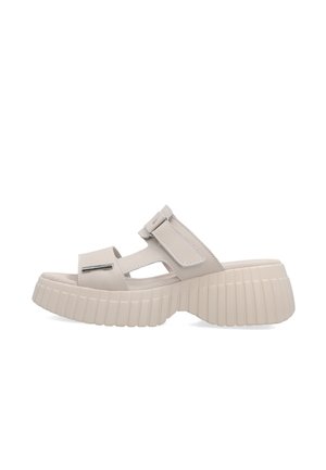 Beige platformsandaal met dikke geribbelde zool, open teen, verstelbare klittenbandriem en uitgesneden zijdetails.