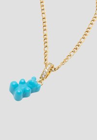 Guld kæde med en turkis gummibjørn pendant. Pendanten har en glat overflade og runde former, pyntet med små klare sten.