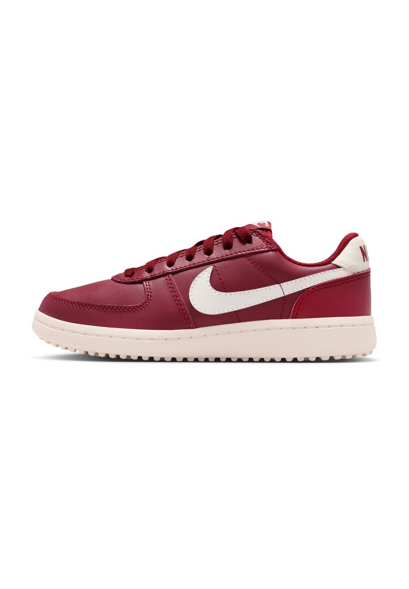 Nike-sneakers van rood leer met witte accenten, voorzien van een ronde neus, veters aan de voorkant en een gestructureerde buitenzool voor grip.