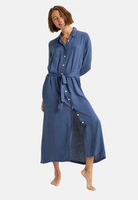 Langes, blaues, knöpfbares Kleid mit einem Bindegürtel, langen Ärmeln und einem Oberschenkel-Schlitz. Aus weichem, leichtem Stoff gefertigt.