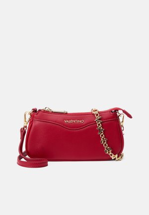 Red leather crossbody bag with a textured finish, gold-tone hardware, and a chain strap. Features a zip closure and embossed logo.