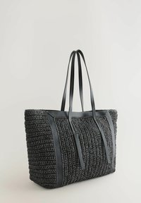 Grand sac fourre-tout arborant une texture tissée noire avec des accents en cuir et des anses doubles. Le design est structuré avec des coutures contrastées.