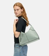 Miętowozielona skórzana torba na ramię o miękkim, zaokrąglonym kształcie, kontrastującym czarnym wykończeniu i eleganckim designie. Regulowany pasek do noszenia.