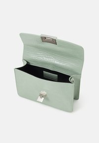 Borsa in finta pelle verde menta con texture coccodrillo, chiusura a scatto argento e fodera interna nera; forma rettangolare.