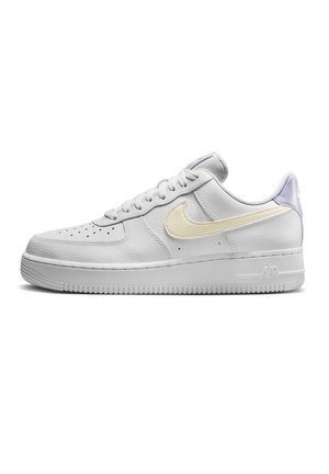 Niskie białe skórzane tenisówki Nike Air Force 1 z kremowym znakiem Swoosh, perforowanym noskiem i płaską gumową podeszwą.