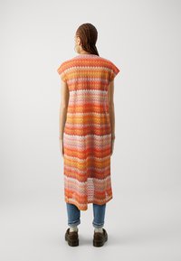 Robe midi multicolore avec un design en tricot à motifs dans des teintes d'orange et de rose, avec des manches courtes et une silhouette ample.