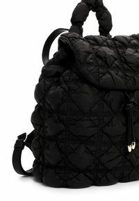 Sac à dos noir matelassé en nylon rembourré, avec un rabat supérieur arrondi, une texture douce, des sangles en cuir réglables et des accents en métal doré.