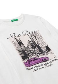 Bílé bavlněné tričko s grafickým potiskem městské ulice, na které je fialové auto, a texty "Pěkné dny" a "Skvělé věci přicházejí."