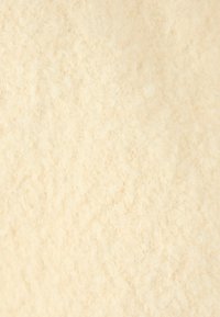 Tela suave y texturizada de color crema con un acabado borroso, que presenta un denso patrón de puntadas entrelazadas. Sin patrones o acentos visibles.