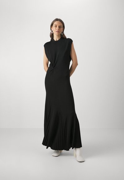 Rochie maxi neagră, făr�ă mâneci, cu un detaliu răsucit în talie și pliuri evazate la margine. Material neted și design minimalist.