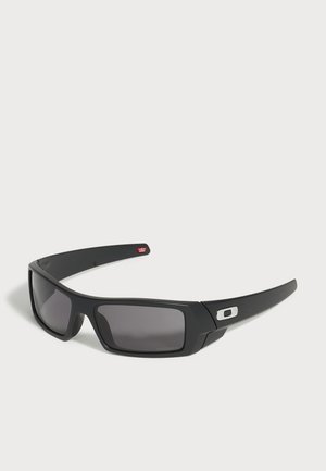 Черни правоъгълни слънчеви очила Oakley с тъмни лещи и малък сребърен лого на десния крак, показани на бял фон.