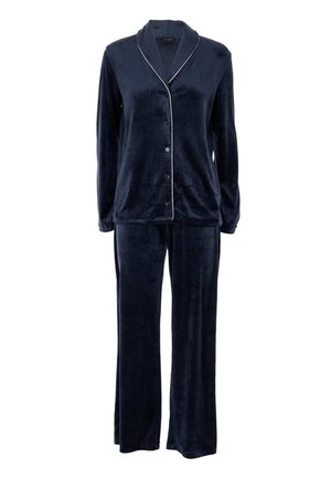 Maglietta da pigiama blu navy in velluto con maniche lunghe e bottoni, abbinata a pantaloni larghi con piping bianco sul colletto e sui bordi frontali.