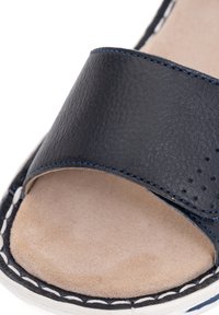 Open-toe navy blue leather sandal with beige cushioned footbed and white stitching along the sole edge.