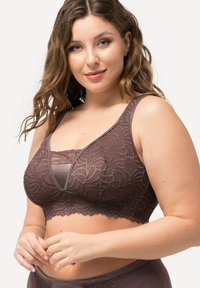 Bruine kant bralette met bloemmotieven, een V-vormige voorkant, brede banden en een cropped ontwerp, aangevuld met een gladde onderlaag.