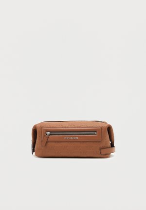 Brun Michael Kors toilettaske med præget logo mønster, frontlomme med lynlås og sidelomme med håndtag på hvid baggrund.