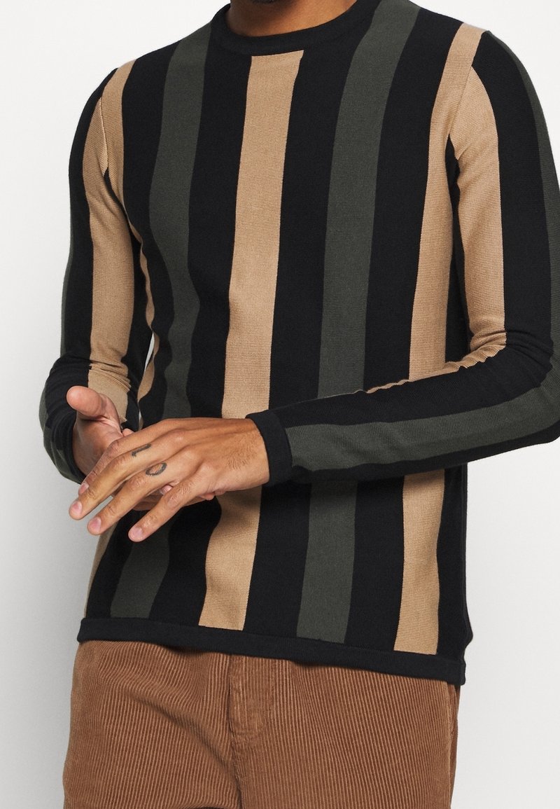 Pull à manches longues avec des rayures verticales en noir, olive et marron clair, doté d'une texture côtelée et d'un col rond.