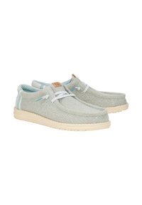 Scarpe in tela azzurro chiaro con lacci bianchi, un'etichetta in pelle beige e una suola di gomma color crema; punta arrotondata e parte superiore testurizzata.