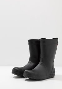 Svarta gummistövlar med en texturerad, räfflad design och en slät yta. Kort höjd, rund tå och svart sulor med bra grepp.