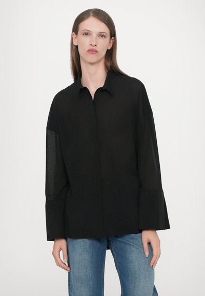 Zwarte overhemd met knopen, een kraag, lange mouwen en een losse pasvorm. Gemaakt van lichtgewicht stof, met een iets doorschijnende textuur.