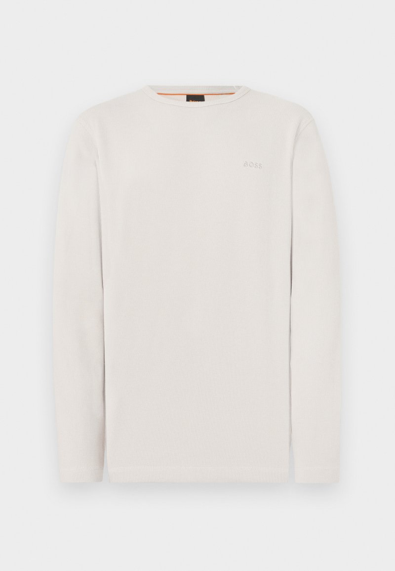 Μεγάλο γκρι πουκάμισο με μακριά μανίκια, κατασκευασμένο από ριμπ ύφασμα. Διαθέτει στρογγυλή λαιμόκοψη και μικρή κεντημένη λογότυπο στο αριστερό μέρος του στήθους.