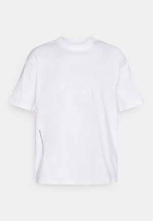 Άσπρη βαμβακερή μπλούζα με κοντά μανίκια, στρογγυλή λαιμόκοψη, χαλαρή γραμμή και μία μικρή εκτύπωση στη ραφή στο πλάι. Λείος υφασμάτινος ιστός, χωρίς μοτίβα.