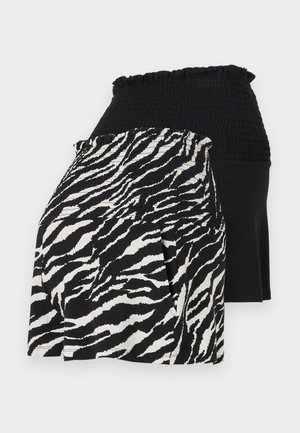 Sorte og hvite lagdelte shorts med smocket midje, den ene siden med zebra mønster og den andre i ensfarget svart stoff.