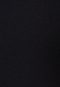 Tessuto nero a coste con una fine trama, caratterizzato da linee verticali uniformi. Il materiale sembra morbido ed elastico, senza decorazioni.