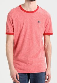 Camiseta de algodón roja jaspeada con mangas cortas, cuello redondo de canalé rojo en contraste y dobladillos de las mangas, que presenta un pequeño parche con el logo de Levi's.