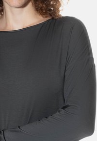Langarm, charcoal grijze top met een brede halslijn. Zacht, lichtgewicht stof met een soepele textuur. Ontspannen pasvorm en gathered mouwen.