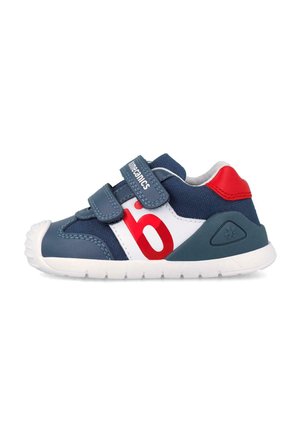 Scarpa da bambino blu navy e bianca con accenti rossi, due cinturini in velcro e suola bianca, vista laterale.