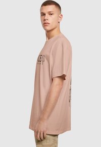 Light pink cotton t-shirt with short sleeves, featuring a front graphic of an ice cream treat and a loose fit.