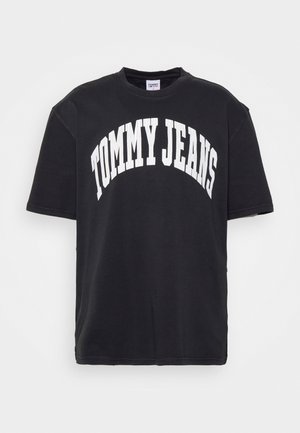 Camiseta de manga corta negra con el texto blanco "TOMMY JEANS" curvado en el pecho.