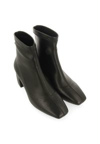 Botas negras de cuero hasta el tobillo con un acabado suave, punta cuadrada y tacón en bloque. Presentan un diseño sin costuras y un detalle de cremallera.