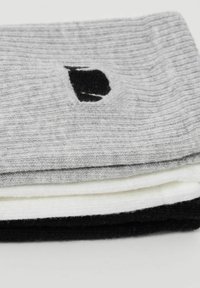Tres pares de calcetines acanalados apilados: grises con un logo negro, blancos y negros. Cada par presenta una textura suave y puños elásticos.