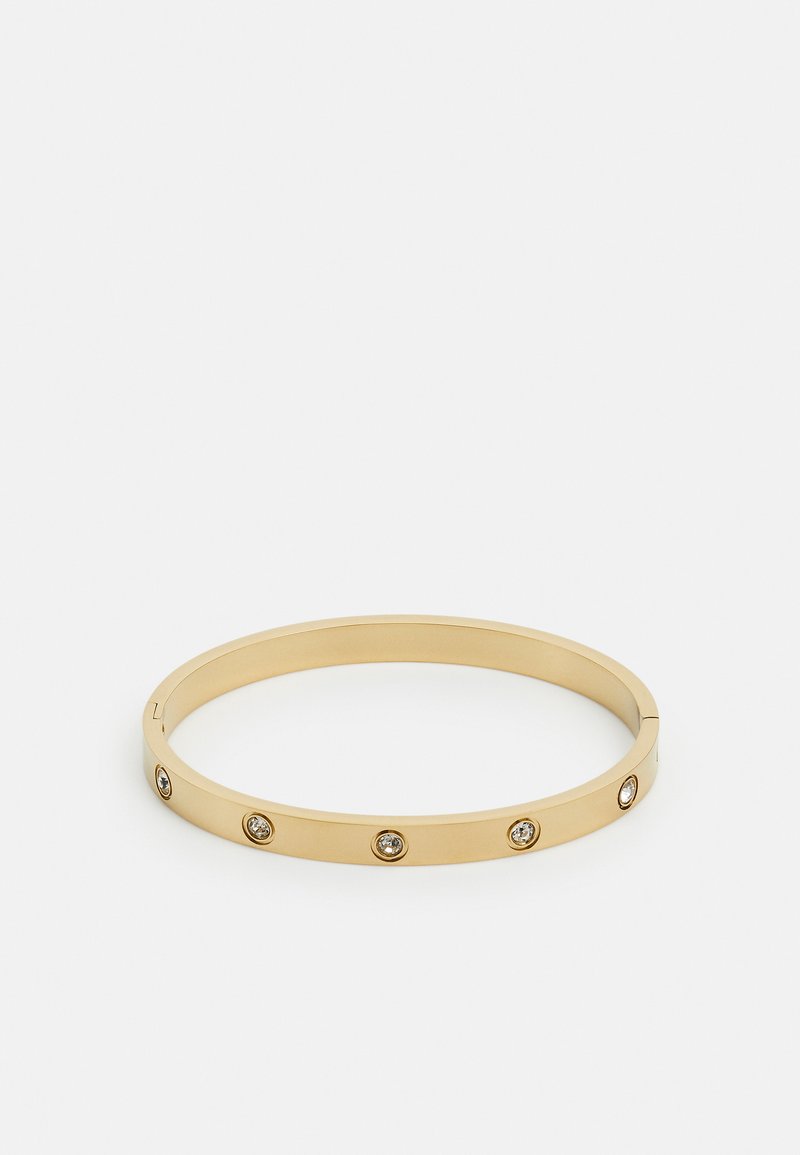 Bracciale rigido in metallo dorato presenta un design liscio e piatto con cinque cristalli trasparenti incastonati, equamente distribuiti attorno al bracciale.