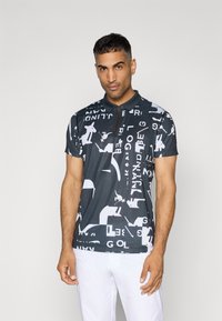 Fekete polo póló grafikus mintával, fehér szimbólumokkal és betűkkel. Rövid ujjú, cipzáros záródással a gallérnál, és slim fit kialakítással.