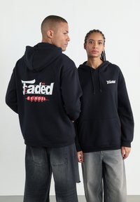 Svarta huvtröjor i mjukt material, med "Fadëd"-logotypen i vitt på både fram- och baksidan, med en känguruficka och justerbar dragsko på huvan.