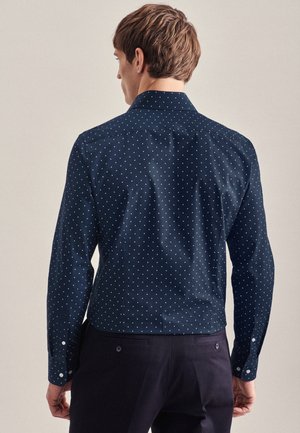 Marineblaues Hemd mit Knöpfen und weißen Punkten, langen Ärmeln und klassischem Kragen, aus einem glatten, strukturierten Stoff gefertigt.