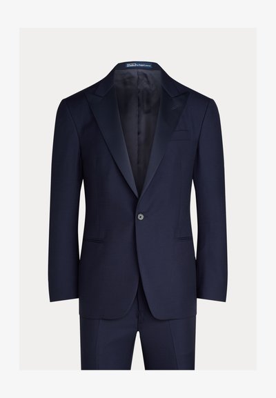 Tamsiai mėlynas kostiumas iš lygaus audinio; turi satino atlapą, vieno mygtuko užsegimą ir tiesias priekinės kišenes.