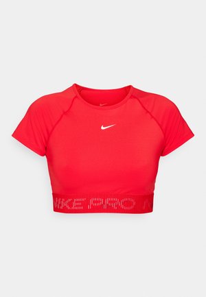 Czerwony, krótki top sportowy z krótkimi rękawami, wykonany z elastycznego materiału. Posiada białe logo Nike oraz teksturowany pas z napisem "NIKE PRO".