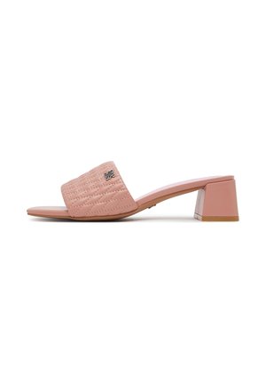 Pink åben tå mule sandal med quiltet rem, lav blokhæl og lille metal logo detalje på remmen mod hvid baggrund.