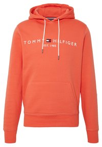 Felpa arancione con cappuccio e lacci, tasca a marsupio, e logo in bianco "TOMMY HILFIGER EST. 1985" sul petto. Tessuto morbido e testurizzato.