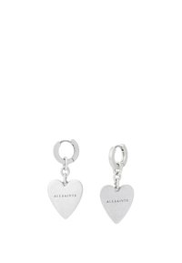 Boucles d'oreilles en forme de cœur en argent avec une finition polie et un logo de marque gravé. Chaque boucle d'oreille présente un anneau circulaire et un charm en forme de cœur suspendu.