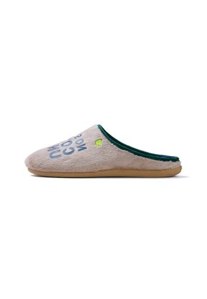 Zapatilla beige suave de tipo slip-on con forro interior verde, suela marrón y texto azul parcialmente visible en la parte superior.