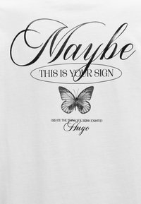 Texte manuscrit « Peut-être que c'est ton signe » au-dessus d'un papillon noir et blanc avec un texte cursif plus petit « Crée ce que tu souhaites voir exister Hugo » en dessous.