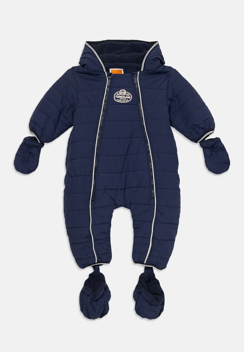 Marinblått vadderat babyoverall med huva, fastsydda vantar och stövlar, framdragkedjor och Timberland-logotyp på bröstet.