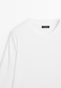 Weißes Baumwoll-T-Shirt mit rundem Ausschnitt und kurzen Ärmeln. Innen am Kragen befindet sich ein schwarzes Etikett mit der Aufschrift "Massimo Dutti".