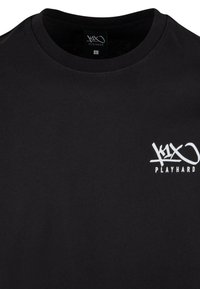 Sort bomulds T-shirt med rund halsudskæring og korte ærmer. Har et hvidt "PLAYHARD" logo på venstre siden. Størrelse angivet som L.